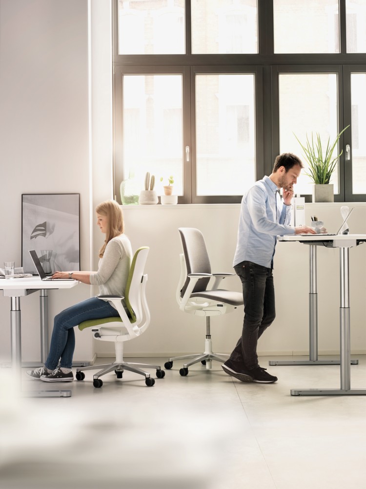AT-Modelle mit erhöhter Sitzposition und zuschaltbarer Vorneigung fördern den Wechsel zwischen Sitzen und Stehen an höhenverstellbaren Arbeitsplätzen.